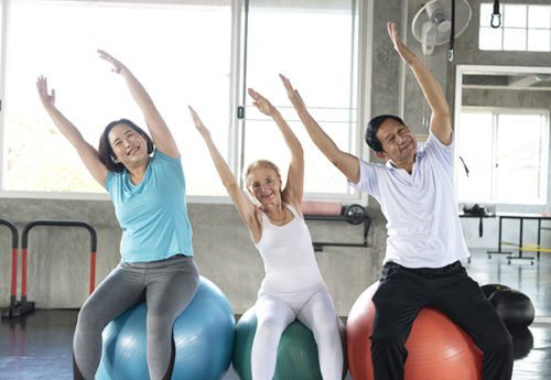 Group of older adults stretching on exercise balls